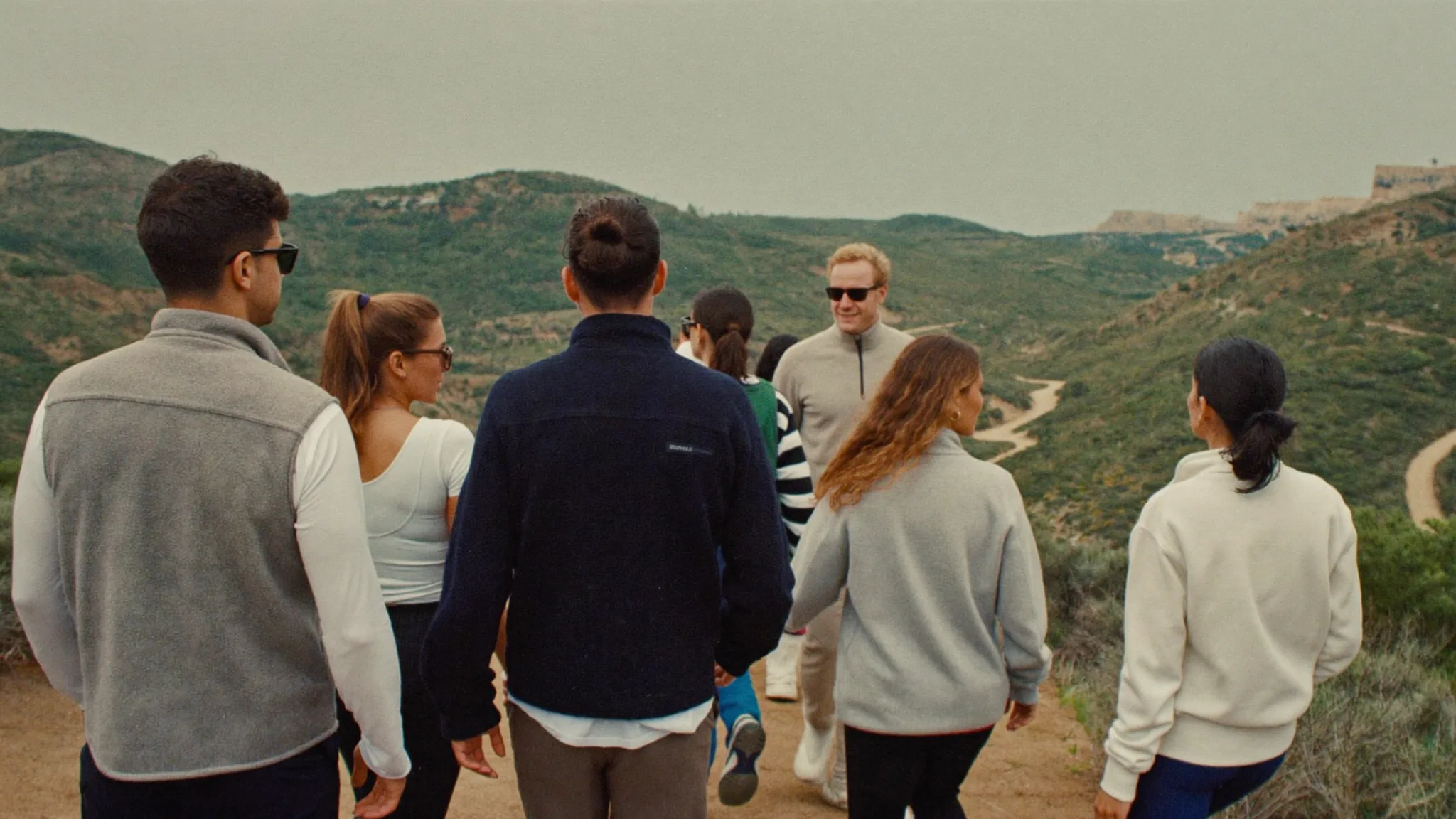 Team walking a coastal trail mid conversation